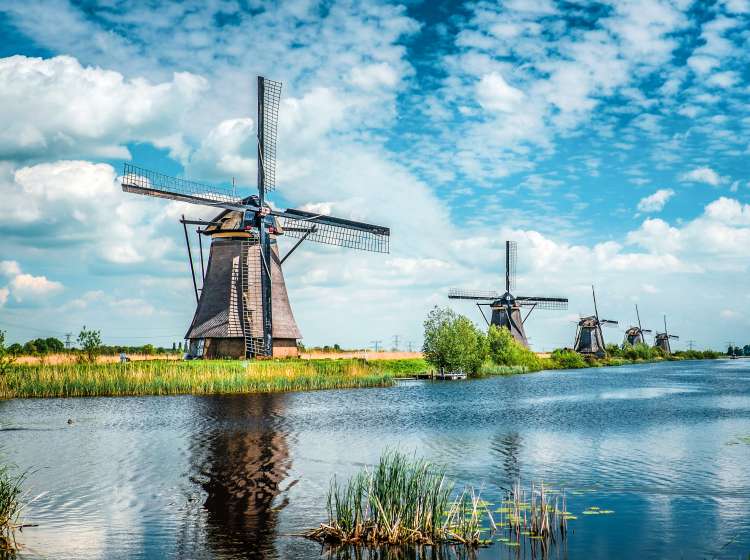 A UNESCO World Heritage. A collection of 18th Century traditional windmills reflected in watter, at Kinderdijk in South Holland Netherlands.