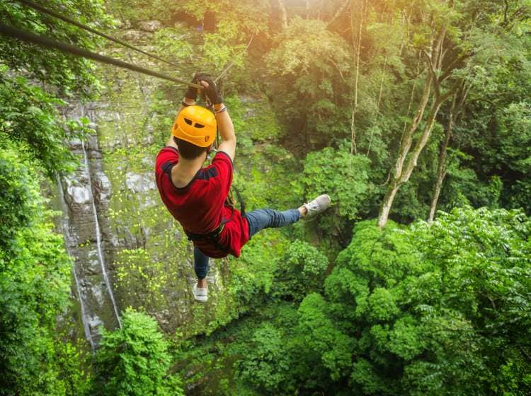 Freedom adult Man Tourist Wearing Casual Clothing On Zip Line Or Canopy Experience In Laos Rain Forest