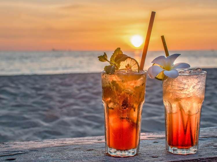 drinks with blur beach and sunset in background