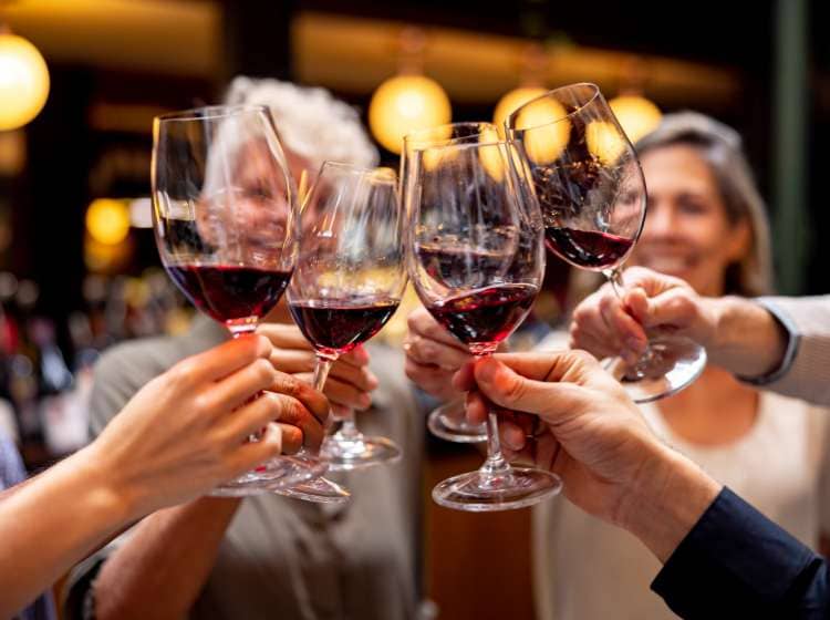 Close-up on a happy group of people making a toast at a wine tasting