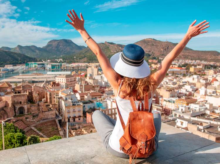 Happy woman traveling looking at panoramic city view- Cartagena and Roman Amphiteater- Murcia province in Spain