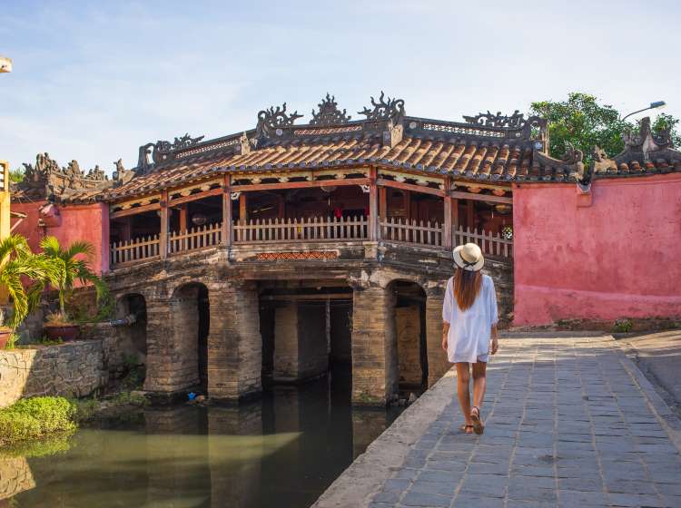 Woman walking in the old town district of Hoi An in Vietnam during a sunny day