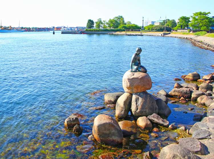 Langelinie promenade with the iconic little mermaid statue & landmark in the foreground and the harbour in the background, Copenhagen, Denmark.