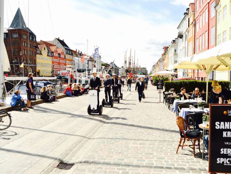 Business-men riding through village street in Copenhagen 