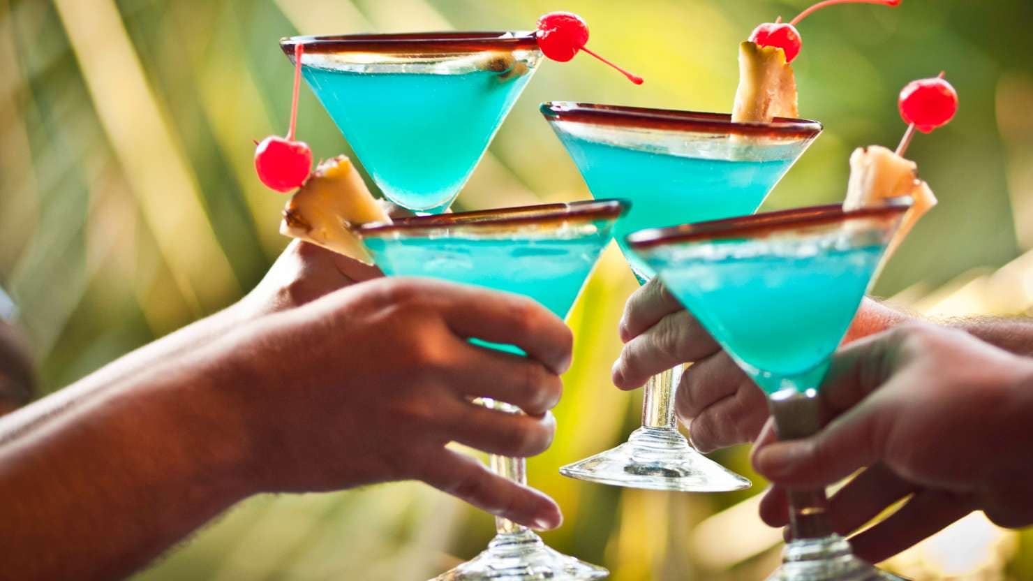 Four friends cheering with Blue Hawaiian drinks.