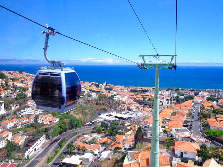 View from the cable car from the seaside to Monte in Funchal, Madeira Island Portugal with a lovely aerial view over the city and sea. Tourists take this way of transport for the views over the city and to visit the botanical gardens in Monte as well as the traditional toboggan ride down the hill.