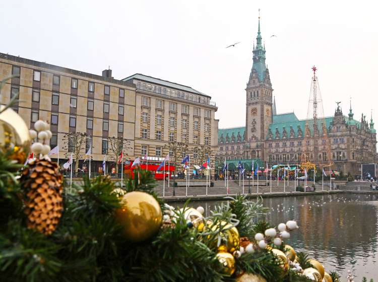 Winter view of Binnenalster lake and Christmas market at Town Hall square near Hamburg Town Hall (Hamburg Rathaus), Germany. Christmas decorations on a foreground