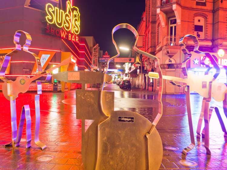 Hamburg, Germany - January 6, 2014: The famous "Beatles-Platz" in Hamburg on the Reeperbahn. The four musicians are represented by their silhouettes that are standing on the edge of the place, that looks like a giant vinyl-record. In the back you can see the street "GroÃe Freiheit" with some passants walking around, where the Beatles started their carreer in several clubs.