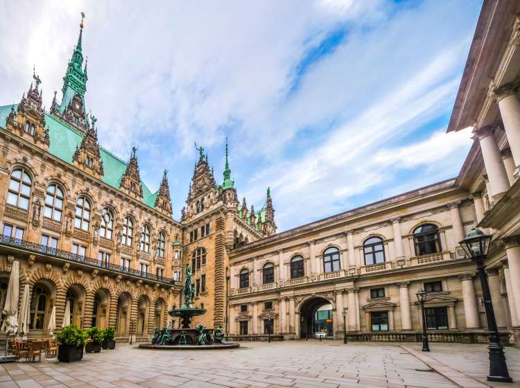 Beautiful view of famous Hamburg town hall with Hygieia fountain from courtyard near market square and lake Binnenalster in Altstadt quarter, Hamburg, Germany