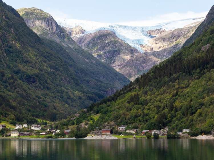 Summer morning in Norway, a village near the small town of Odda, on the river Opo. In the background you can see the glaciers of Folgefonna National Park.