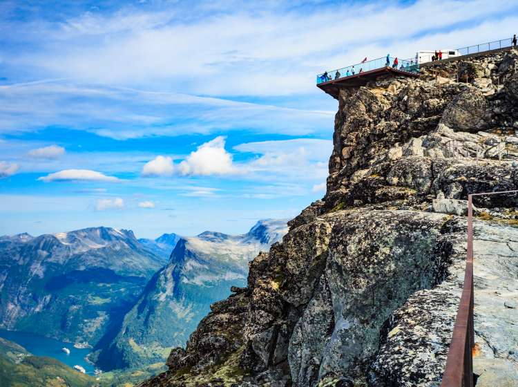 Panoramic mountains landscape with Geirangerfjord from Dalsnibba area. Geiranger Skywalk viewing platform on mountain in distance. Norway.