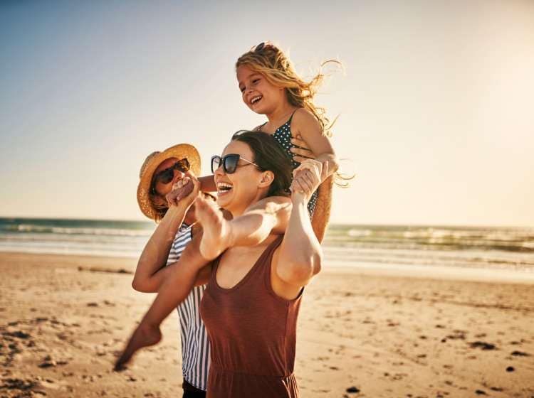 Shot of an adorable little girl spending the day at the beach with her parents