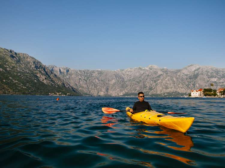 Young men paddle a kayak on the sea in Boka bay, Montenegro; Shutterstock ID 455527711; Invoice Number: -