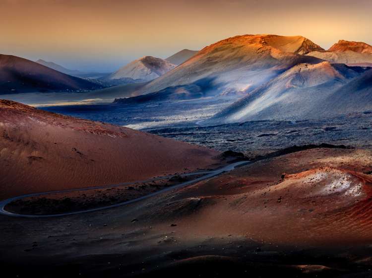 The u-turn road in the middle of the vulcano landscape on Lanzarote island looks not like located on our planet.