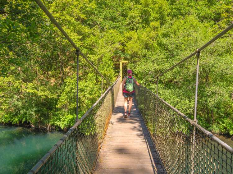 Woman walking along Fragas do Eume Natural Park. It is one of the best-preserved riverside Atlantic forests in Europe. âFragaâ means a forest with different species of trees. It is the most important example of the survival of the indigenous forest in the coastal area of Galicia.