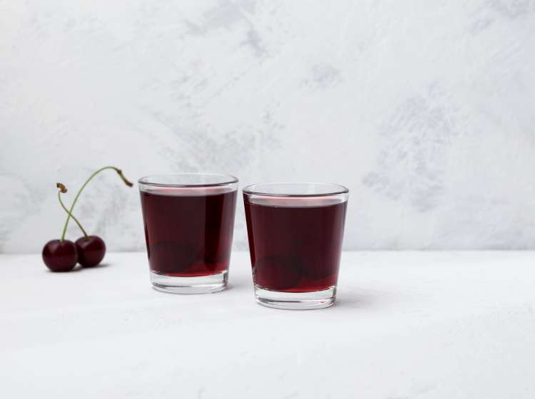 Ginjinha or Ginja - Portuguese liqueur made by infusing ginja berries (sour cherry, Prunus cerasus austera, Morello cherry) in alcohol (aguardente) and adding sugar. Selective focus, copy space.