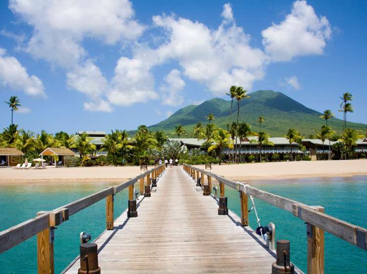 Stunning Pinney's beach with Coconut Palms, and the Volcano in the distance, at Nevis. Caribbean