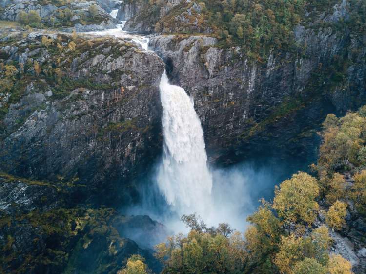 This captivating photograph showcases the breathtaking sight of a Norwegian waterfall cascading gracefully into a fjord. The powerful rush of water against the backdrop of the tranquil fjord landscape creates a sense of natural wonder and awe. Perfect for conveying the grandeur of Norwegian fjord waterfalls, the beauty of the union between land and water, or evoking a feeling of admiration and reverence for the pristine natural landscapes of Norway, this image adds a touch of timeless beauty and the captivating allure of a Norwegian waterfall at a fjord's edge.