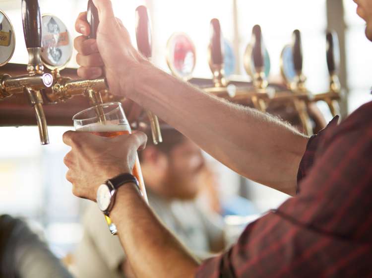 Close-up of bartender making cask beers at bar