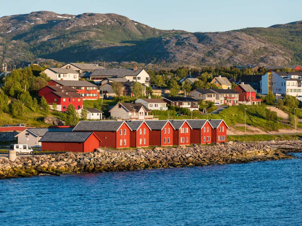 Houses near water infront of mountains