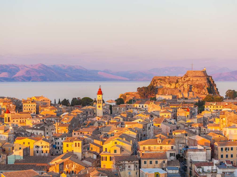 buildings and castle overlooking sea