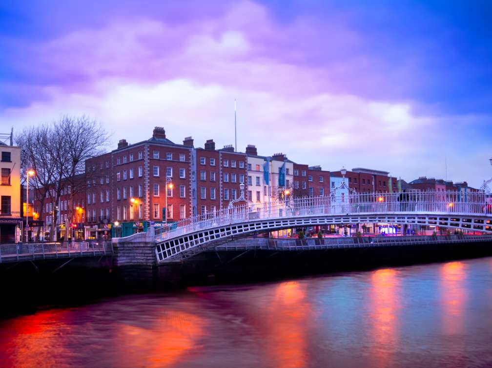  A bridge over a river with a purple and blue sky