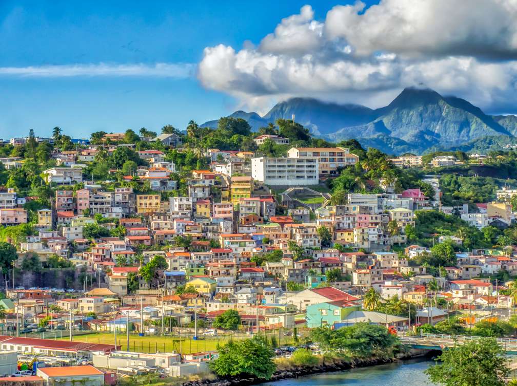 View of big town by the river in front of mountains
