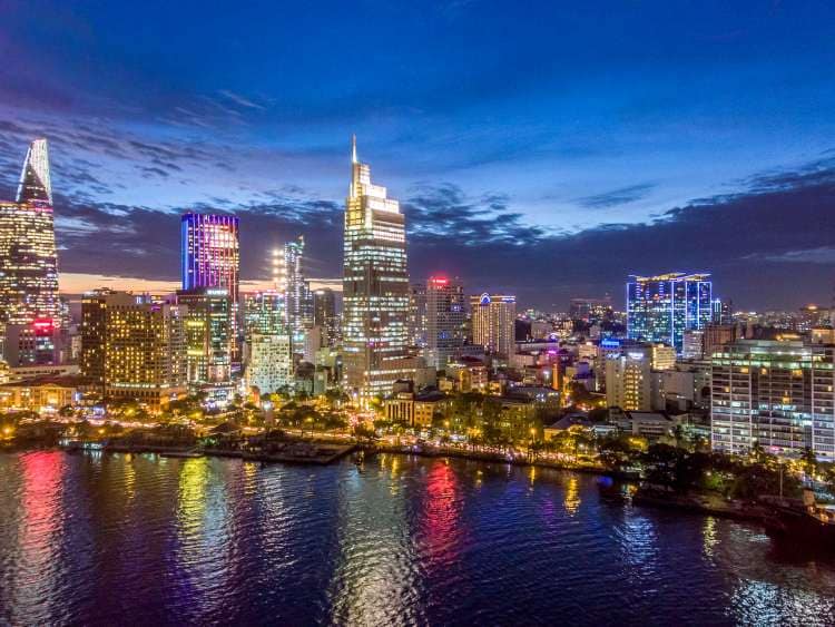 City lit up by lighting in buildings by the sea 
