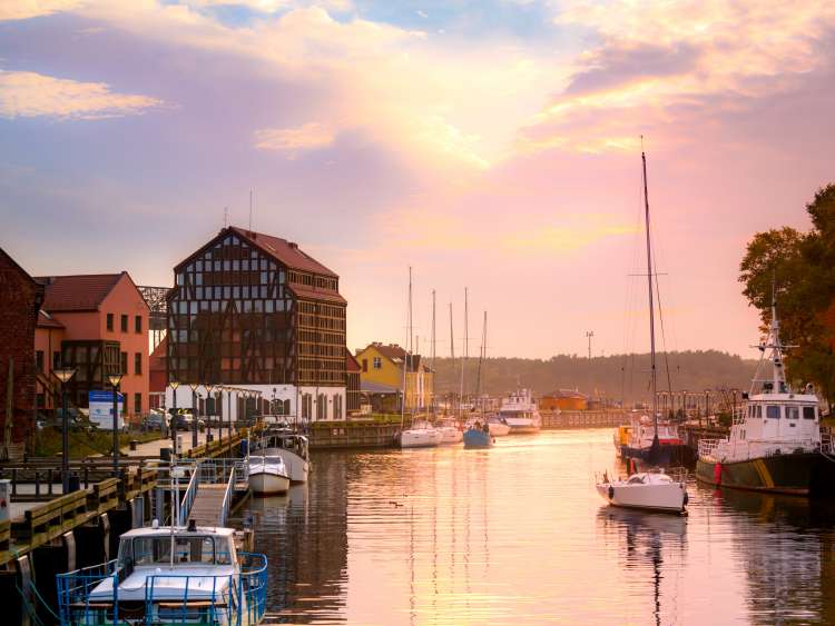  A river with boats on by houses