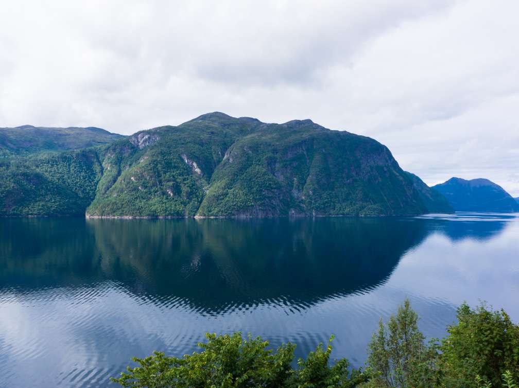 Green mountains behind water