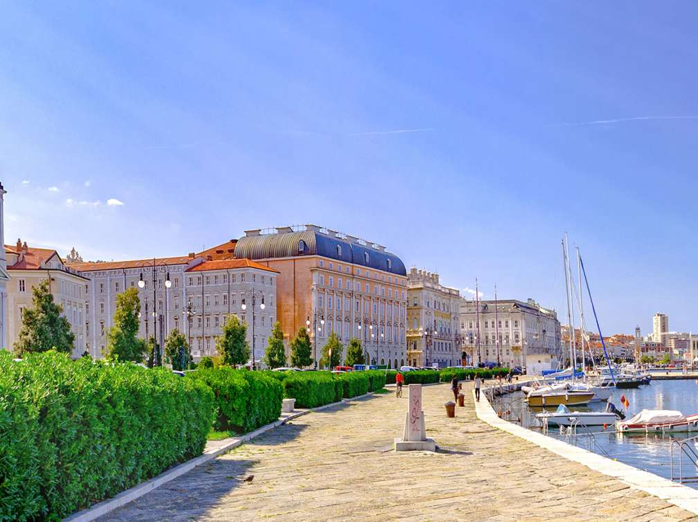 Small path alongside sea with boats in Trieste, Italy