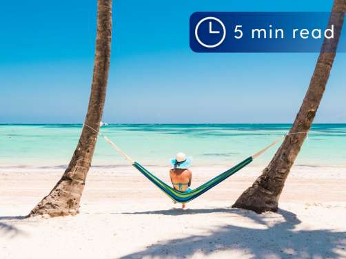 Woman sat on Hammock by the sea in the Caribbean