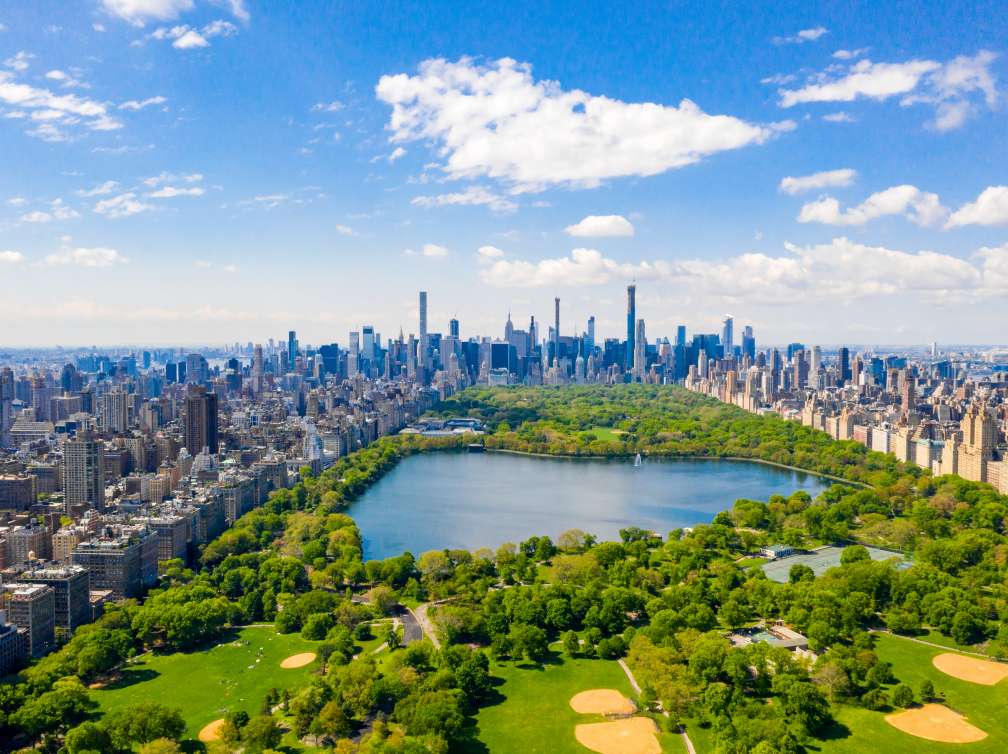 Aerial view of the Central park in New York with golf fields and tall skyscrapers surrounding the park.