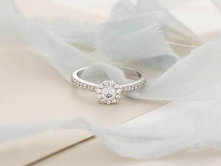 Stylish silver engagement ring with gemstones. Wedding concept with copy space. Advertising jewelry still life