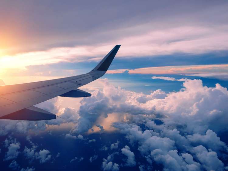 Close-up of airplane wing flying at sunrise
