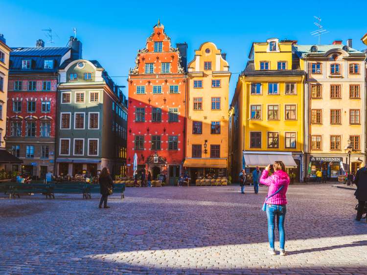 A tourist photographing the iconic buldings at Stortorget.