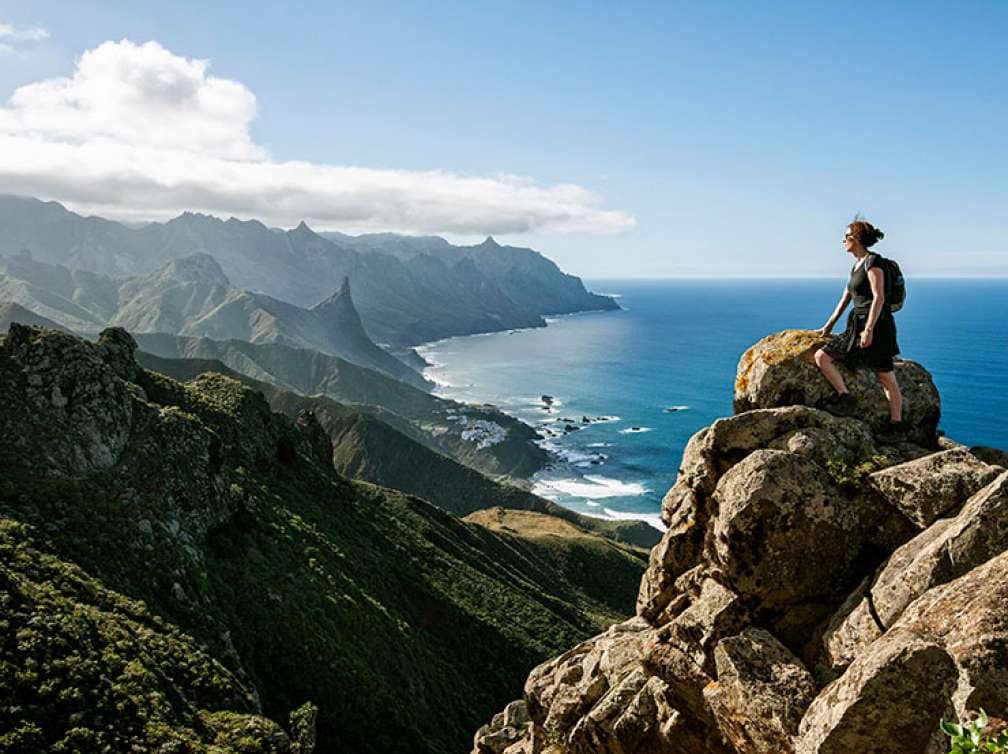 Woman climbing up rocks on the Tenerife coastline