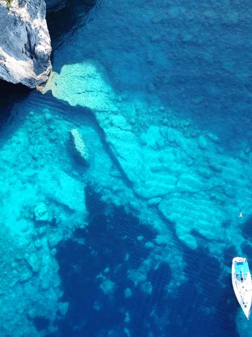 Aerial drone photo of sail boats anchored in tropical Caribbean island paradise bay with white rock caves and turquoise clear sea; Shutterstock ID 1166039707; project: olly; job: ; client: pocruises; other: 
