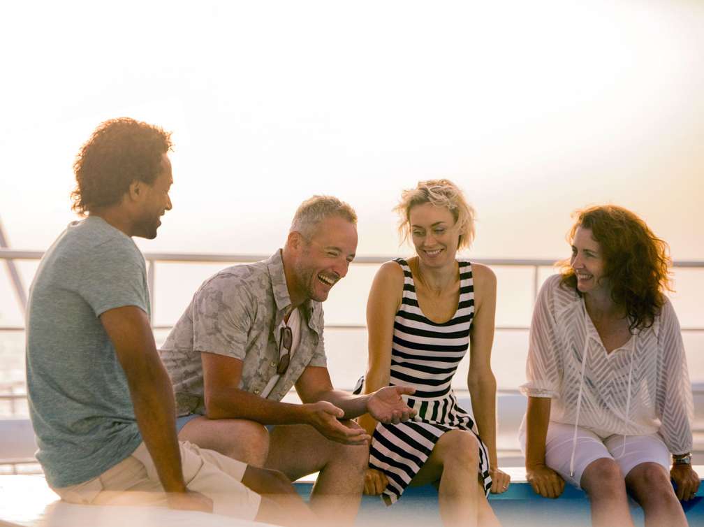 Friends laughing together on sunbed on deck of P&O Cruises ship