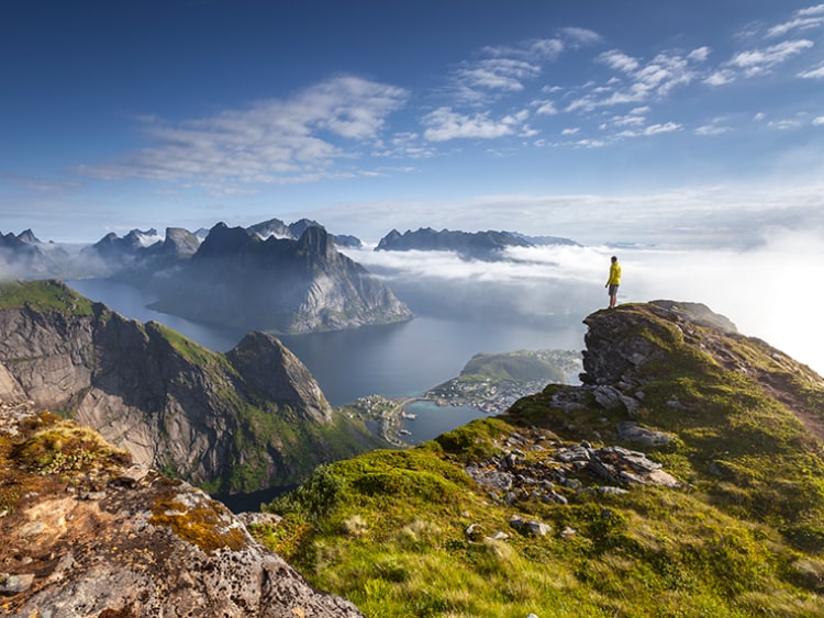 Man standing on rock at the top of Fjord