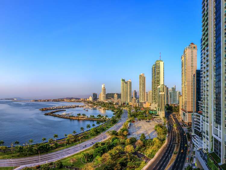 Panoramic high angle view of Panama City, high buildings against blue sky, in front blue sea.