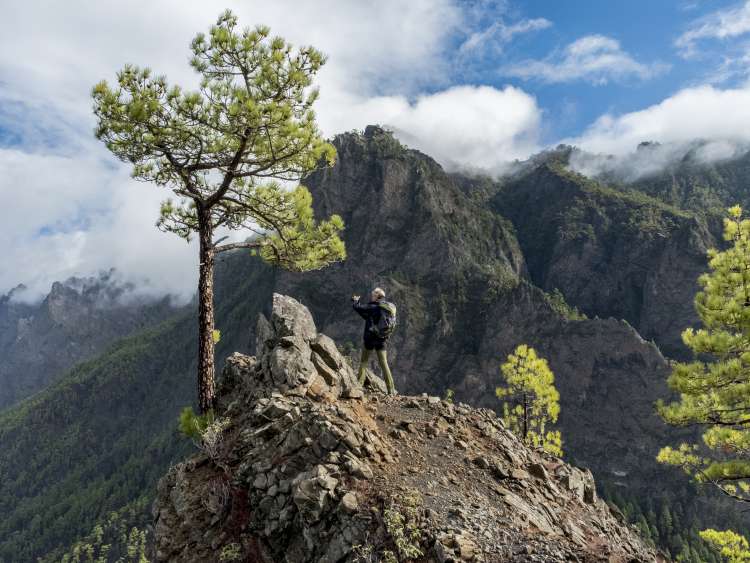 Cumbrecita mountains in the "Caldera de taburiente" national park. The picture shows a photographing female backpacker at a steep rocky viewpoint of the park.; Shutterstock ID 543055231; Client: P&O Cruises; Job: Winter itineraries toolkit; Licensee: Isabella