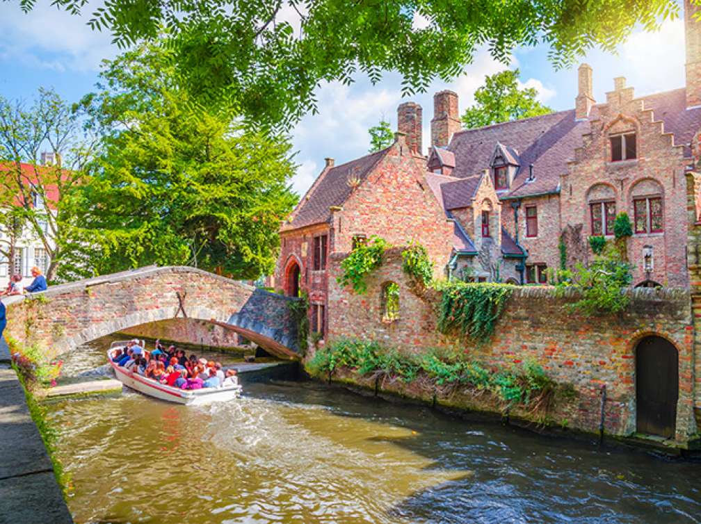 Boat going under Bonifacius Bridge in Old Town Bruges, Belgium