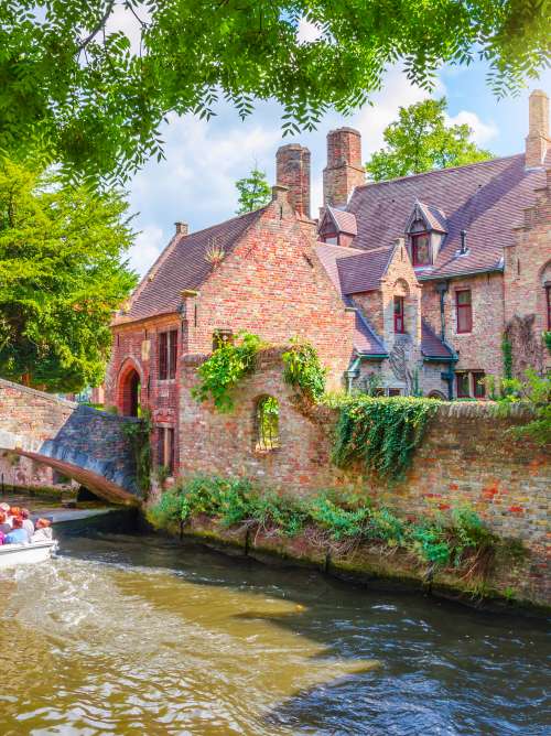 Boat going under Bonifacius Bridge in Old Town Bruges, Belgium