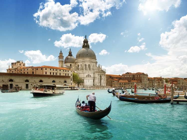 Basilica di Santa Maria della Salute in Venice next to gondolas in the Grand Canal