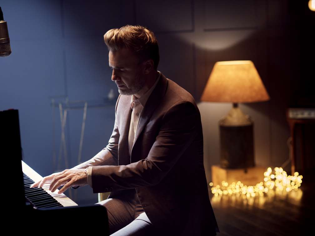 Gary Barlow playing the piano in the 710 Club on board P&O Cruises ships