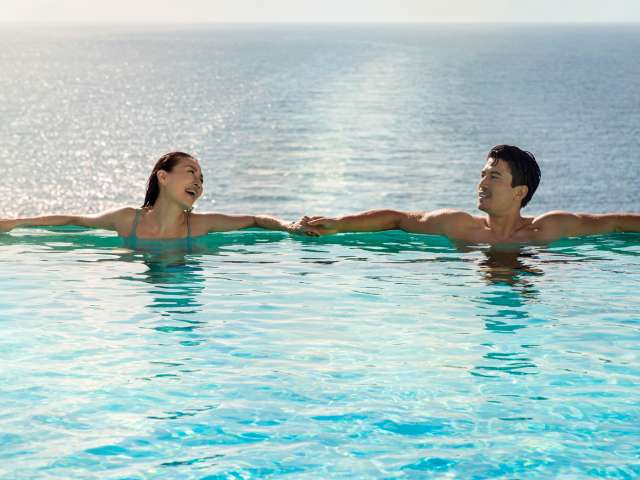 Couple enjoying infinity pool on board P&O Cruises ships Iona and Arvia 