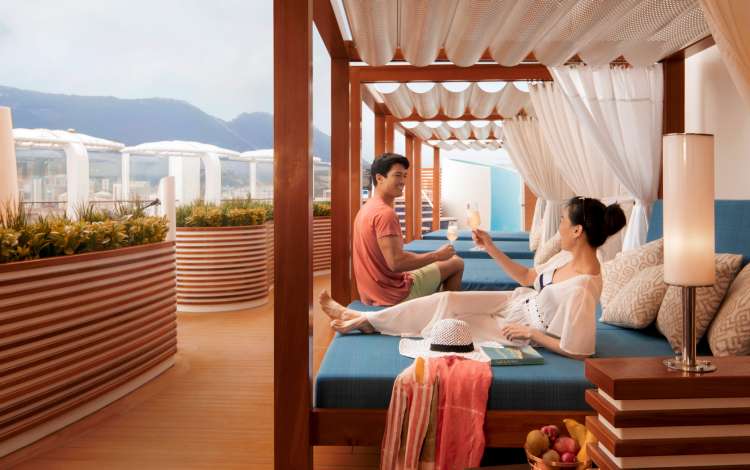 Couple enjoying a drink on a sunbed in The Retreat on P&O Cruises ship Iona