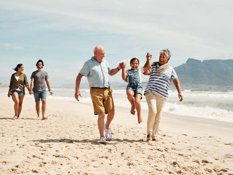 Shot of an adorable little girl having a fun day at the beach with her parents and grandparents