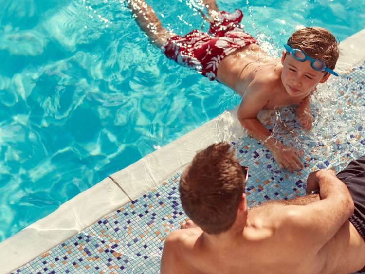 Father and son in the swimming pool on a family friendly cruise ship